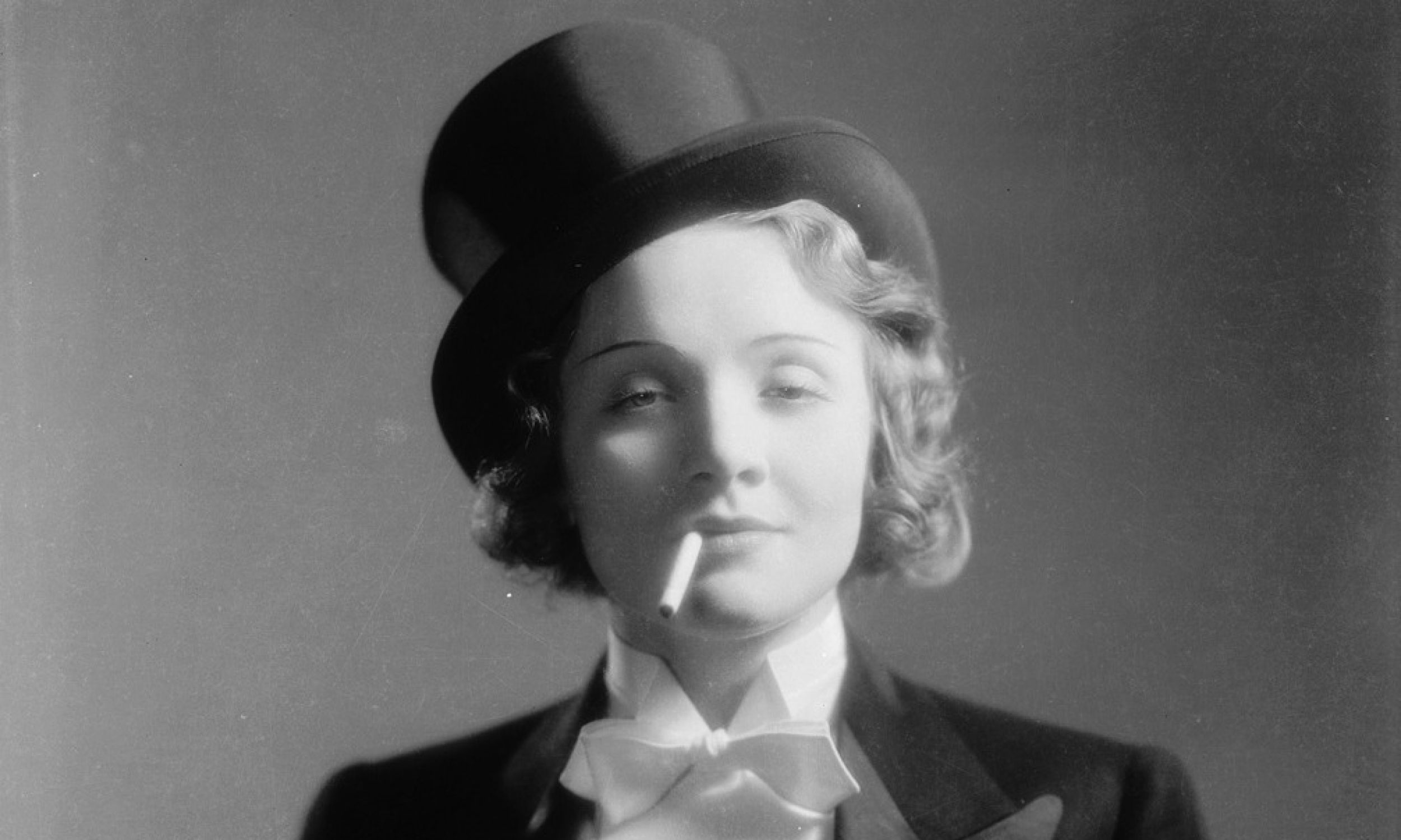1930: Marlene Dietrich (1901 - 1992) debiutowała w Hollywood jako ubrana w smoking Amy Jolly w filmie „Maroko” w reżyserii Josefa von Sternberga. Męskie stroje - spodnie, marynarki, kapelusze, krawaty, muchy - i papierosy stały się jej wyróżnikiem. Fot. Eugene Robert Richee/ John Kobal Foundation/Getty Images) Amy Jolly