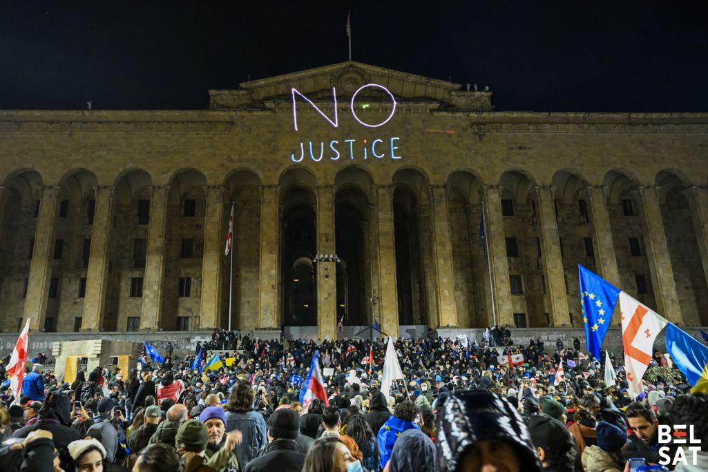 Надпіс «no justice» (ніякай справядлівасці) бачная на будынку парламенту Грузіі падчас акцыі пратэсту. Фота: Белсат