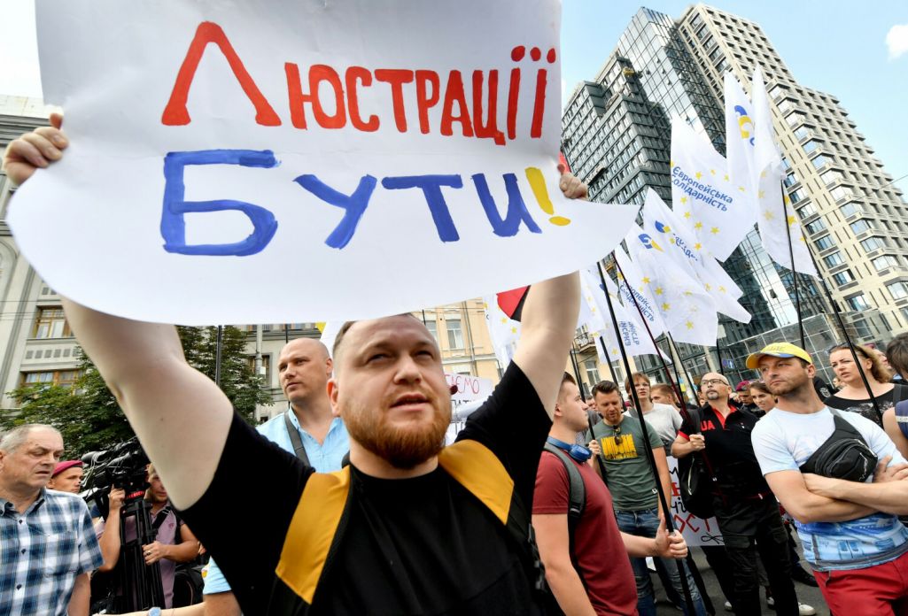 Здымак мае ілюстрацыйны характар. Актывіст з плакатам на акцыі пратэсту ля будынку Канстытуцыйнага суда Украіны падчас разгляду справы аб канстытуцыйнасці законаў аб люстрацыі і дэкамунізацыі. Кіеў, Украіна. 4 ліпеня 2019 года. (Фота: Sergei Supinsky / AFP / East News)