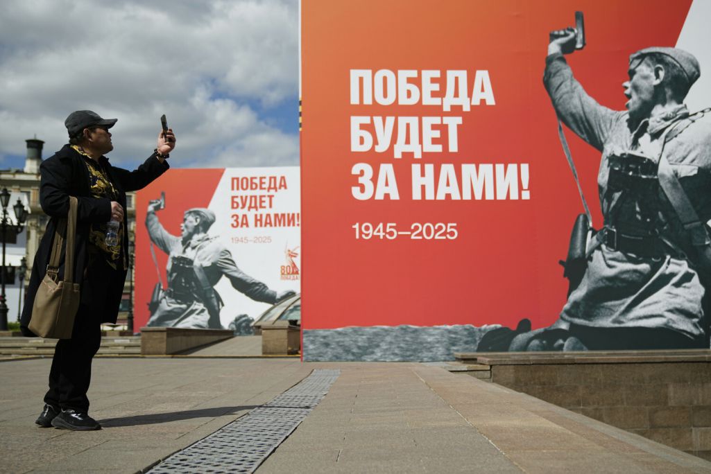 Напярэдадні святкавання 80-й гадавіны перамогі ў Другой сусветнай вайне мужчына фатаграфуе плакат са здымкам «Камбат» савецкага фатографа Макса Альперта, на якім выяўлены савецкі афіцэр падчас Другой сусветнай вайны. Масква, Расея. 6 траўня 2025 года. Фота: Pavel Bednyakov / AP Photo / East News