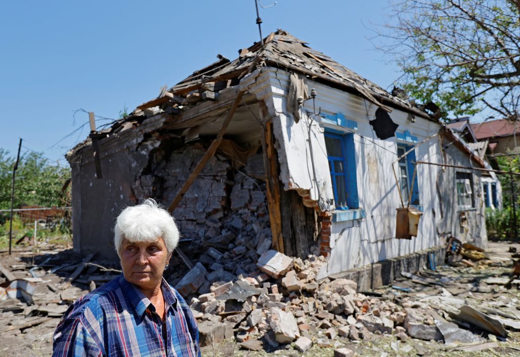 Жанчына стаіць каля разбуранага дому. Горад Ясінаватая, Данецкая вобласць, Украіна. 6 ліпеня 2024 г. (Фота: Alexander Ermochenko / Reuters / Forum)