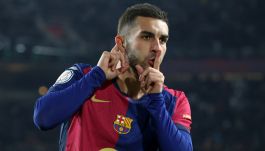 Na zdjęciu widzimy piłkarza FC Barcelony Ferrana Torresa w charakterystycznym granatowo-bordowym stroju drużyny, wykonującego gest uciszania po zdobyciu bramki. W tle widać rozmazane trybuny stadionu, co sugeruje, że zdjęcie zostało zrobione w trakcie meczu. Zawodnik wygląda na pewnego siebie i skoncentrowanego – jego postawa dobrze oddaje determinację i sportowe emocje towarzyszące rywalizacji w El Clásico (fot. Getty Images)