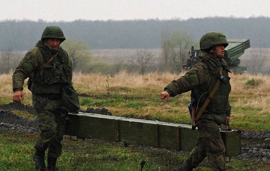 Вайскоўцы РФ пераносяць скрыню з рэактыўным снарадам для сістэмы залпавага агню «Град». Фота: Виталий Тимкив / РИА «Новости»