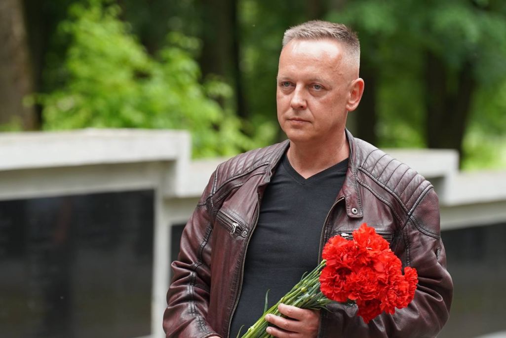 Томаш Шмыт ускладвае кветкі на могілках польскіх ваяроў у вёсцы Леніна Горацкага раёну, Беларусь. 6 чэрвеня 2024 года. (Фота: Mogilevnews / Telegram)