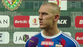Napastnik Polonii Bytom udziela pomeczowego wywiadu po zwycięstwie 3:2 nad Śląskiem Wrocław. W tle widoczne są logotypy sponsorów i Betclikc 1 ligi, a piłkarz w niebiesko-czerwonym stroju z herbem Polonii mówi o sile zespołu i swoim golu na 3:1 (fot. TVP)