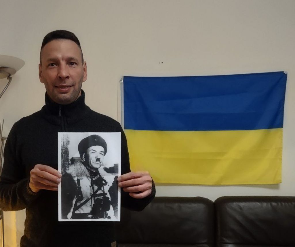 Міхаіл Татарнікаў на фоне дзяржаўнага сцягу Украіны трымае ў руках партрэт Героя Савецкага Саюзу генерала-маёра Івана Панфілава. Фота перадаў Белсату герой гэтага матэрыялу