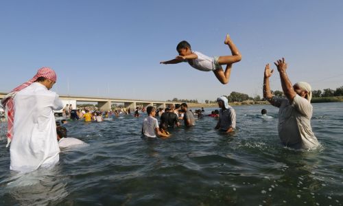 Mieszkańcy zajętego przez ISIS miasta kąpiacy się w Eufracie. Fot. REUTERS/Stringer