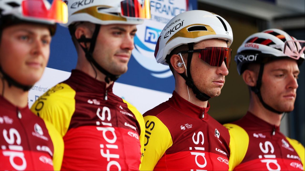 Czterech kolarzy zespołu Cofidis w czerwono-żółtych strojach z logo sponsora, w białych kaskach z napisem 'EKOI' i okularach przeciwsłonecznych, stoi obok siebie podczas oficjalnego wydarzenia sportowego. W tle widoczny baner 'COUPE DE FRANCE' z logo FDJ. (fot. Getty Images)