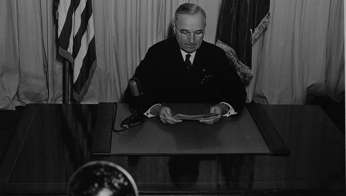 US President Harry S. Truman seated at a desk, before a microphone, announcing the end of World War II in Europe, Photo: Wikimedia Commons/National Archives and Records Administration. Office of Presidential Libraries. Harry S. Truman Library.