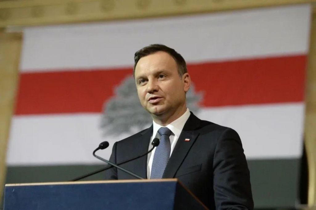 Прэзідэнт Польшчы Анджэй Дуда стаіць на фоне бел-чырвона-белага сцяга. Крыніца: viasna96 / Telegram