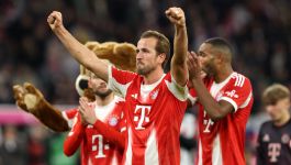 Na zdjęciu widzimy triumfujących piłkarzy Bayernu Monachium tuż po zakończeniu meczu, który przypieczętował ich historyczny wyczyn. W centrum kadru znajduje się Harry Kane z uniesionymi ramionami, wyrażającymi dumę i radość. Jego gest mówi więcej niż tysiąc słów — to chwila chwały, która przechodzi do historii. W tle widać uśmiechniętych kolegów z drużyny, bijących brawo i celebrujących razem z nim, a także klubowego misia, który dodaje scenie lekkości i klubowego ducha (fot. Getty Images)