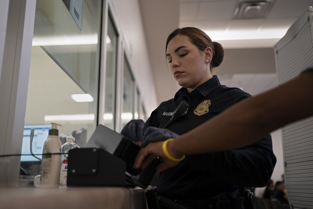 Агент Пограничного патруля США снимает отпечатки пальцев мигранта, записанного на прием через приложение CBP One, 2023 год. Фото: Danielle Villasana for The Washington Post via Getty Images