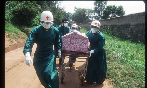 Pracownicy służby zdrowia transportują trumnę zakonnicy, która zmarła na skutek zakażenia wirusem Ebola w styczniu 1995 r. w Kikwit w Zairze. Fot. Malcolm Linton / Liaison